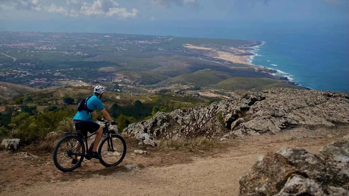 Cyclists on electric bikes riding toward Guincho Beach near Cascais and Sintra on a guided e-bike tour